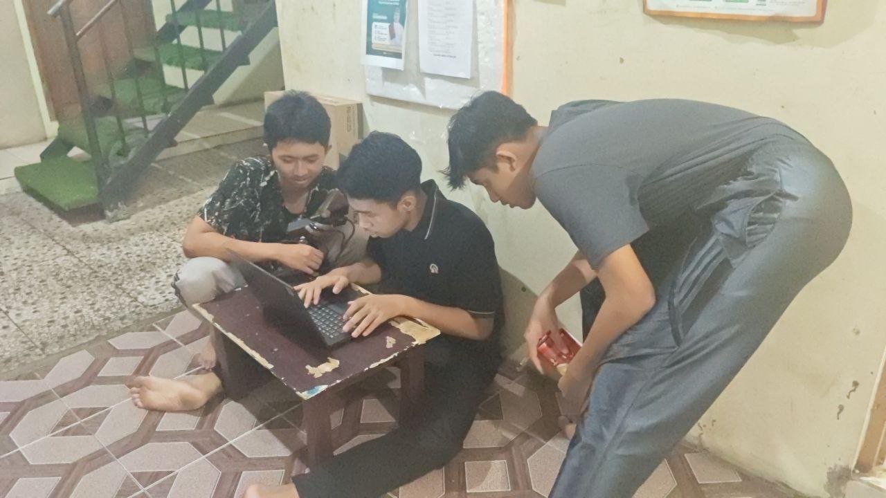 A group of people sitting on the floor looking at a computer AI-generated content may be incorrect.