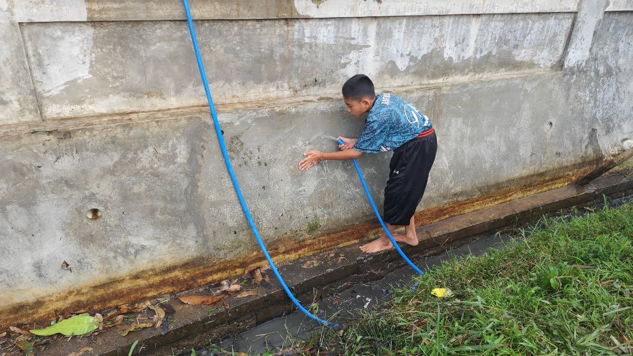 A child holding a blue hose

AI-generated content may be incorrect.