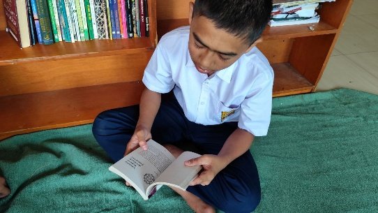 A child sitting on the floor reading a book

AI-generated content may be incorrect.