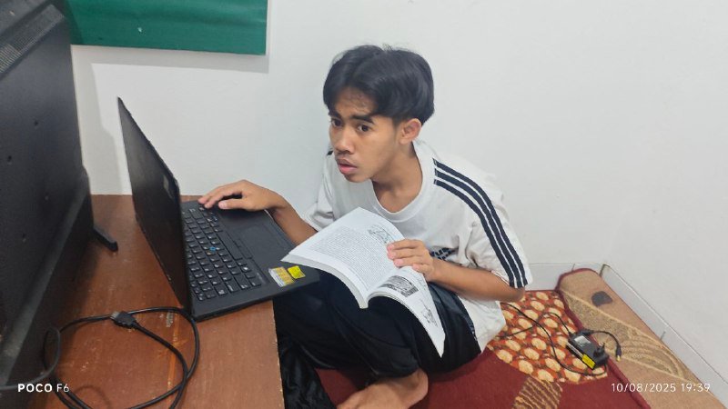 A person sitting on the floor with a book and computer AI-generated content may be incorrect.