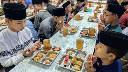A group of people sitting at a table with food
AI-generated content may be incorrect.