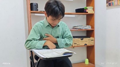 A child sitting at a desk with his hand on his chest

AI-generated content may be incorrect.